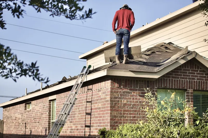 Professional roofer working on a residential roof in Heather Gardens